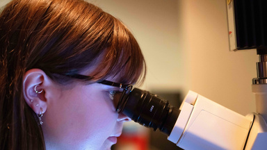 Abby Myroth looking into microscope